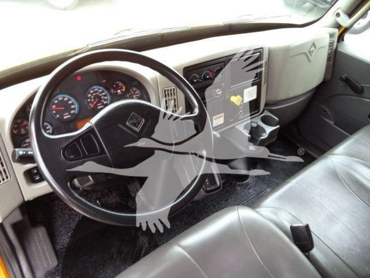 Truck cab interior showing steering wheel and dashboard of a 2019 International Durastar 4300 with OEM gauges and center console.