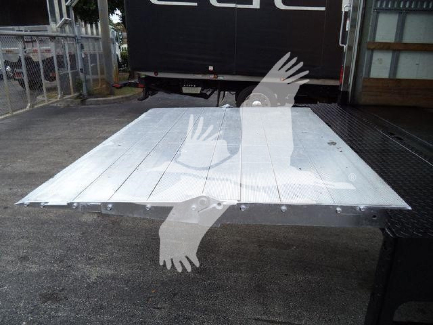 Flat aluminum truck bed platform on a 2019 International Durastar 4300, viewed from above; metal surface with bolts along edges, open cab area in background.