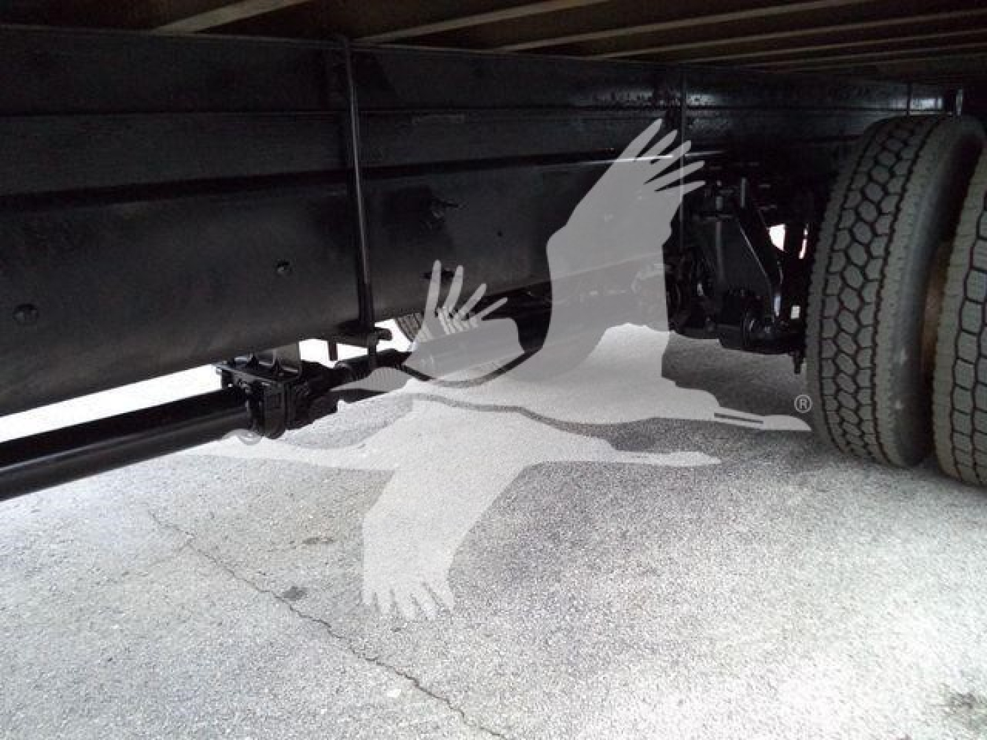 Truck undercarriage showing frame rails and a rear wheel on a box truck.