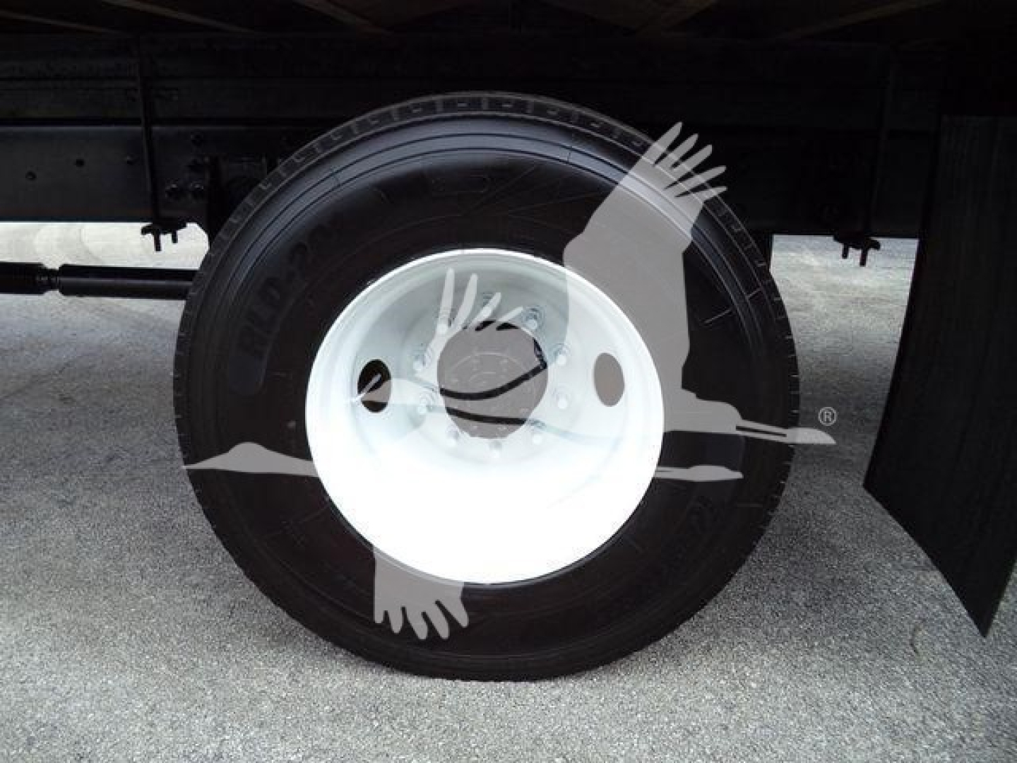 Wheel and tire assembly under a Box truck showing steel white wheel and black tire.