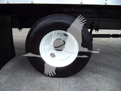 Wheel and tire close-up on a box truck undercarriage with white steel rim and black tire.