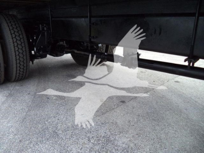 Box truck undercarriage showing frame rails and axle with dual rear wheels; side chassis and underbody components visible.