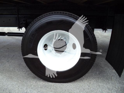 Wheel and tire assembly under a Box truck showing steel white wheel and black tire.
