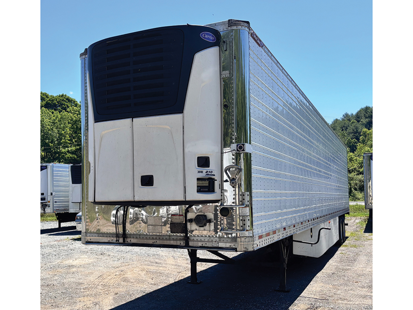 Great Dane Everest SS trailer rear view showing refrigeration unit and reflective aluminum sides, front landing gear visible.