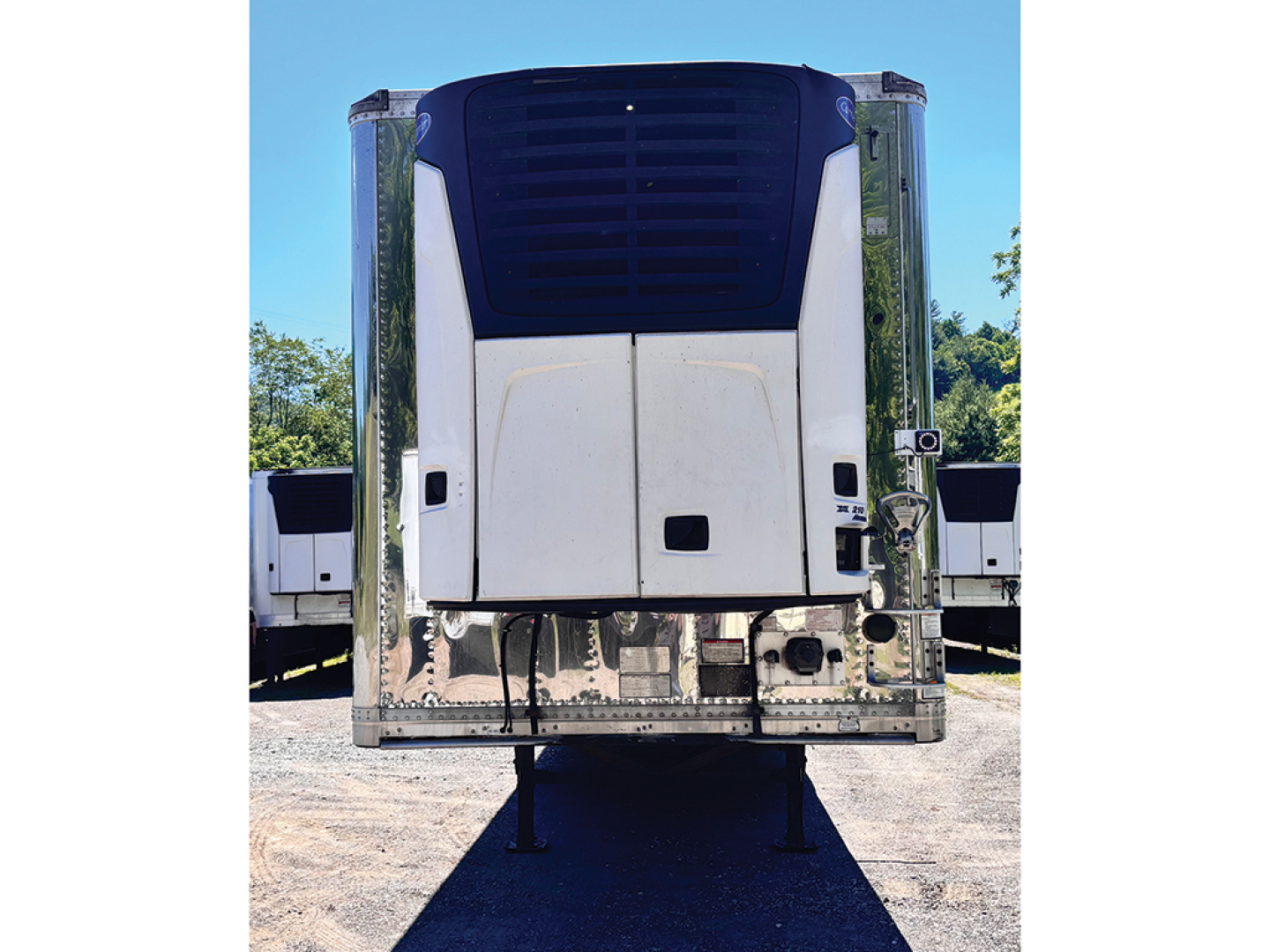 Rear view of a 2015 Great Dane Everest SS trailer with blue upper front panel and chrome vertical side rails, showing landing gear and bumper.