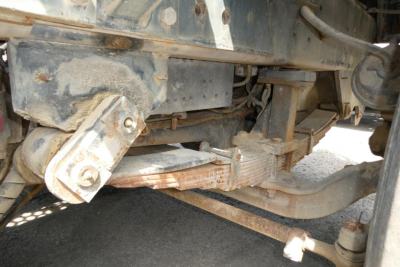 Kalmar Ottawa YT30 truck undercarriage showing suspension and linkage components with rust residue.