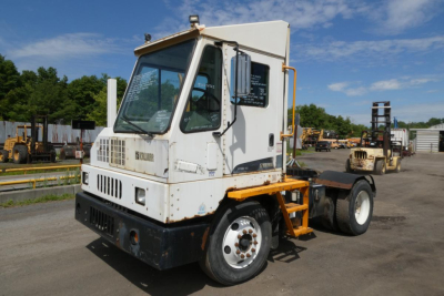 Kalmar Ottawa YT30 yard truck chassis with cab and exposed rear wheels, white cab with black grille, yellow steps, and black undercarriage.