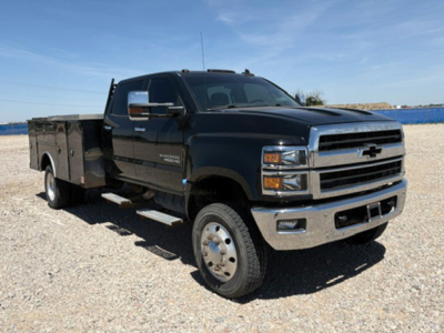 Chevrolet 4500 Silverado HD service body crew cab 4x4 front angled view showing chrome grille, large bumper, utility bed with compartments.