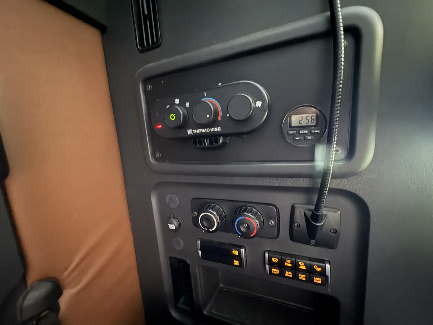 Dash area of Freightliner Cascadia 126 showing climate controls, gauge, auxiliary gauge, switches, and cab interior.