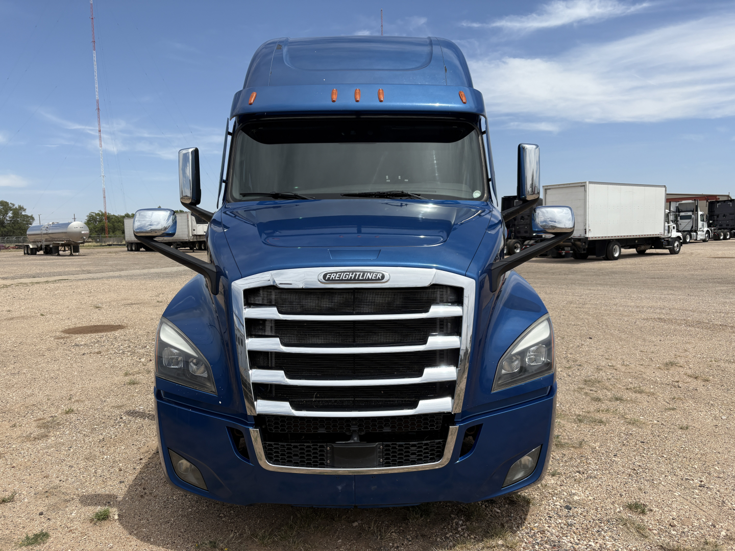 Freightliner Cascadia 126 truck front view showing blue cab, prominent grille, and large headlights.