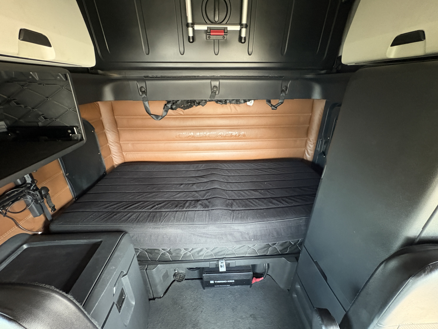 Freightliner Cascadia 126 sleeper cab interior cargo area showing bed and side panels.