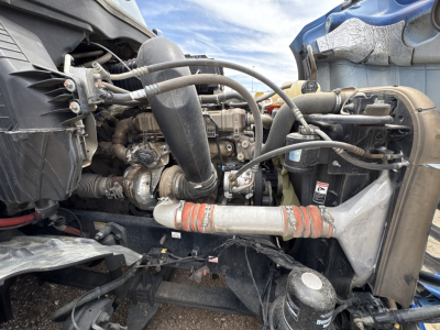 Freightliner Cascadia 126 engine bay with hoses, intercooler, radiator, and turbo piping visible.