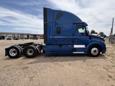 Blue 2022 Freightliner Cascadia 126 tractor-trailer side view showing sleeper cab and rear wheels