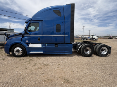 Freightliner Cascadia 126 sleeper cab tractor side view showing blue exterior, wheels, and exhaust stack.