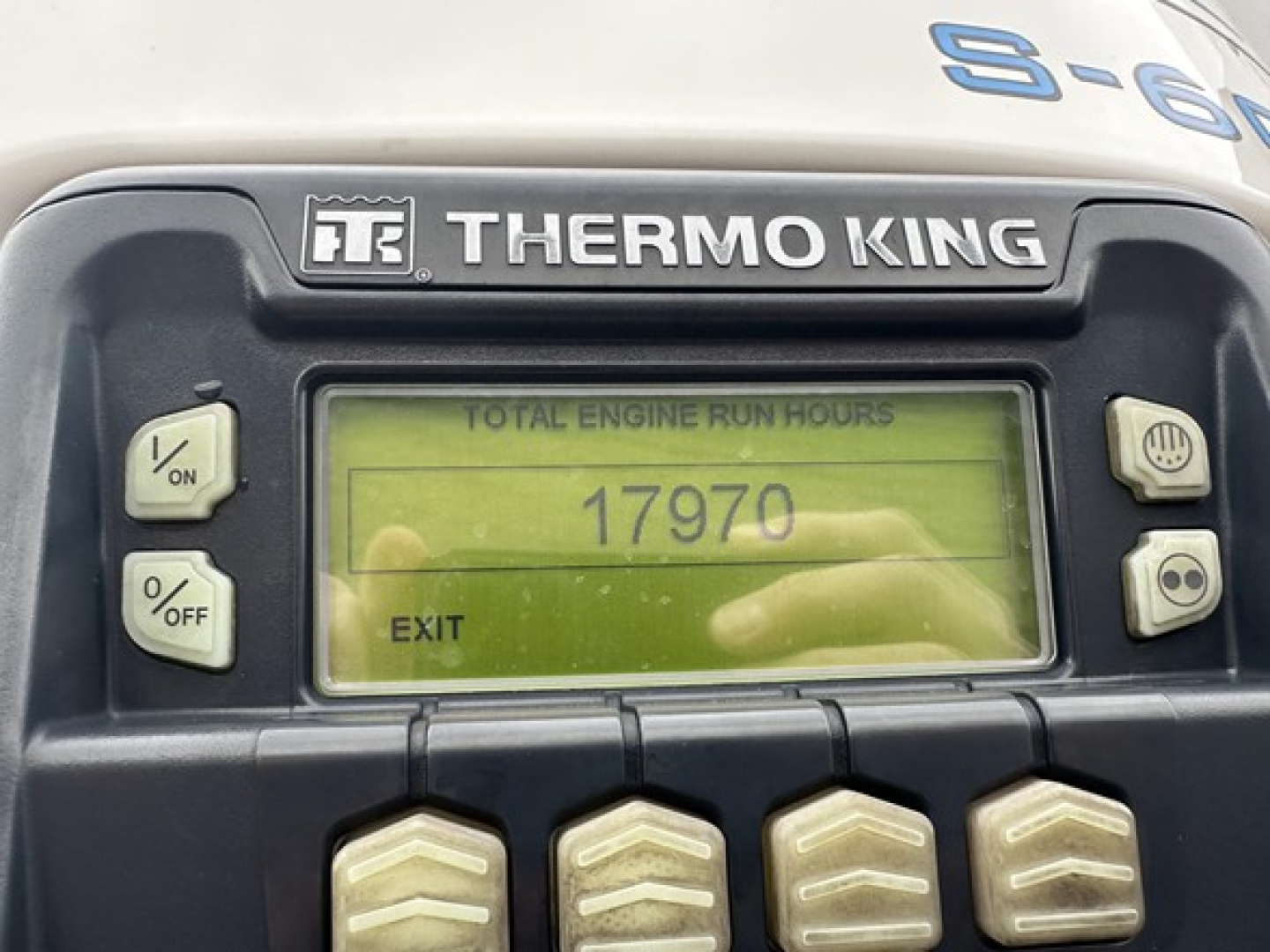 Thermo King controller panel showing total engine run hours 17970 with EXIT on display. Left side has ON/OFF and %/OFF buttons; right side has two round buttons.