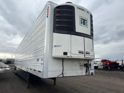 Utility 3000R trailer with Thermo King refrigeration unit at front, white body, vertical '3000R' text on nose, chassis landing legs visible in foreground, other trailers in background.