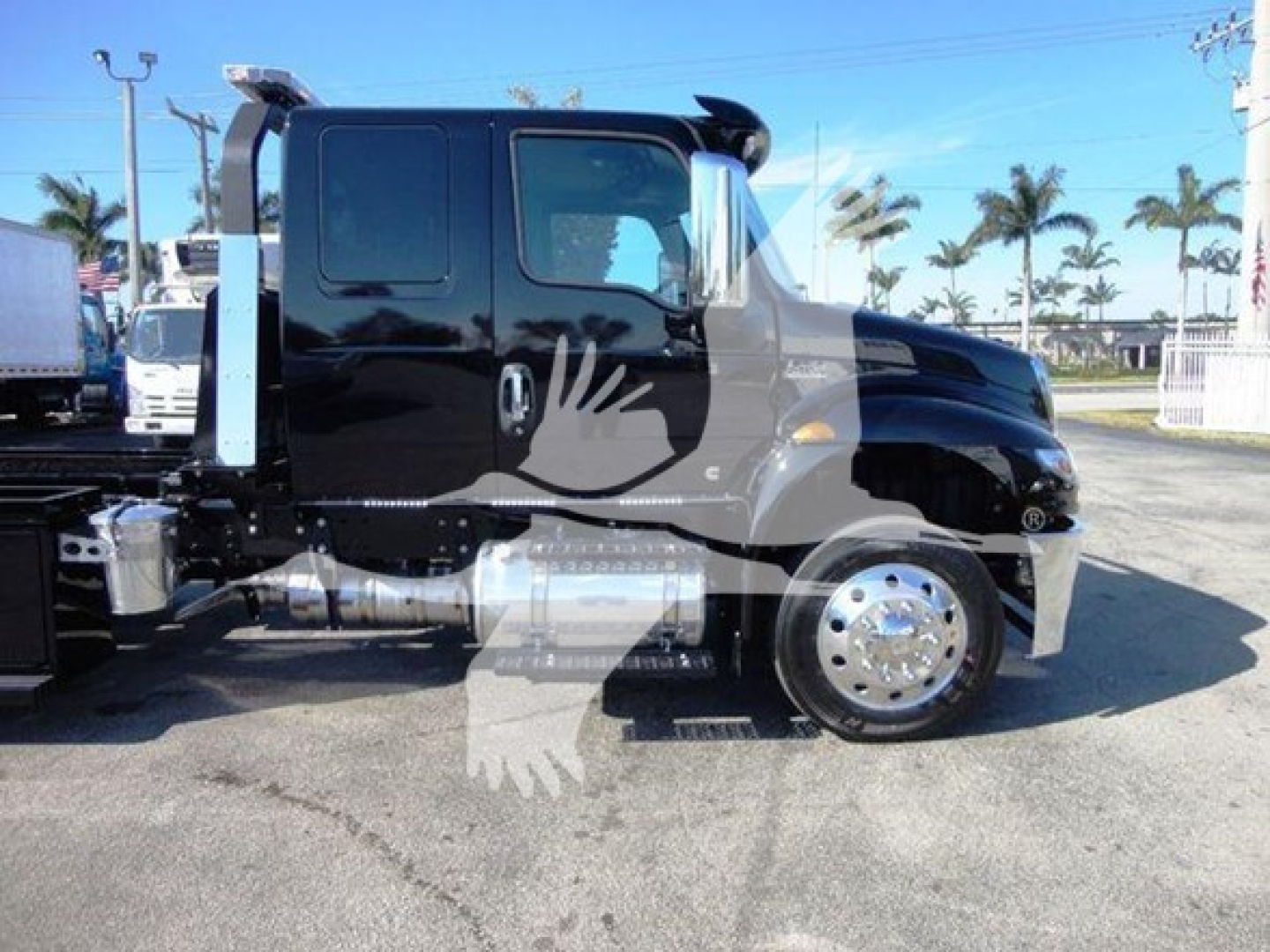 International MV 2022 rollback truck side view showing cab, black paint, chrome fuel tanks, and rear wheel; VIN 3HAEUMML7ML615011 visible on listing.