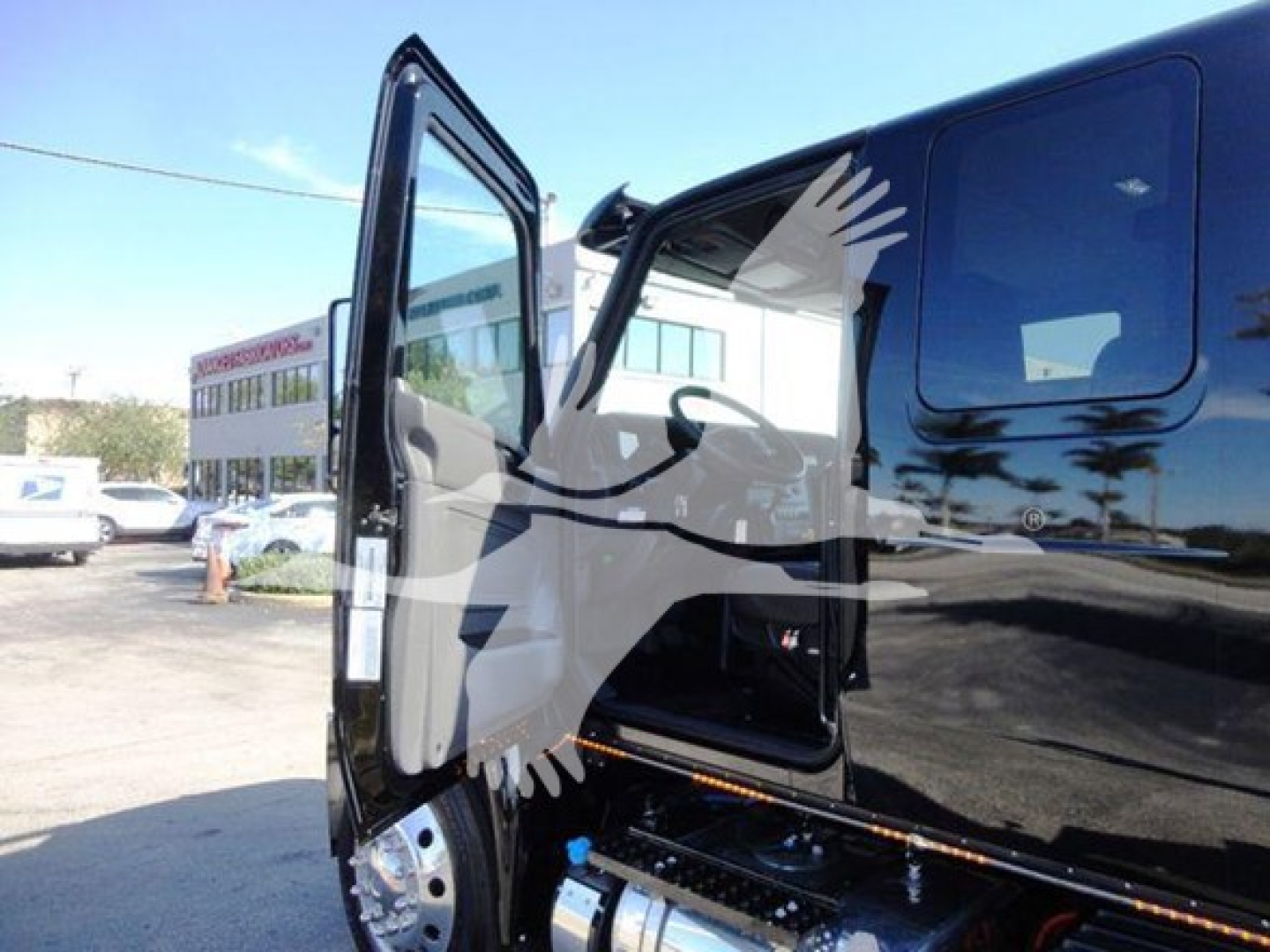 Truck cab door area of a 2022 International MV with open door showing interior; black body, side steps, and glossy finish.