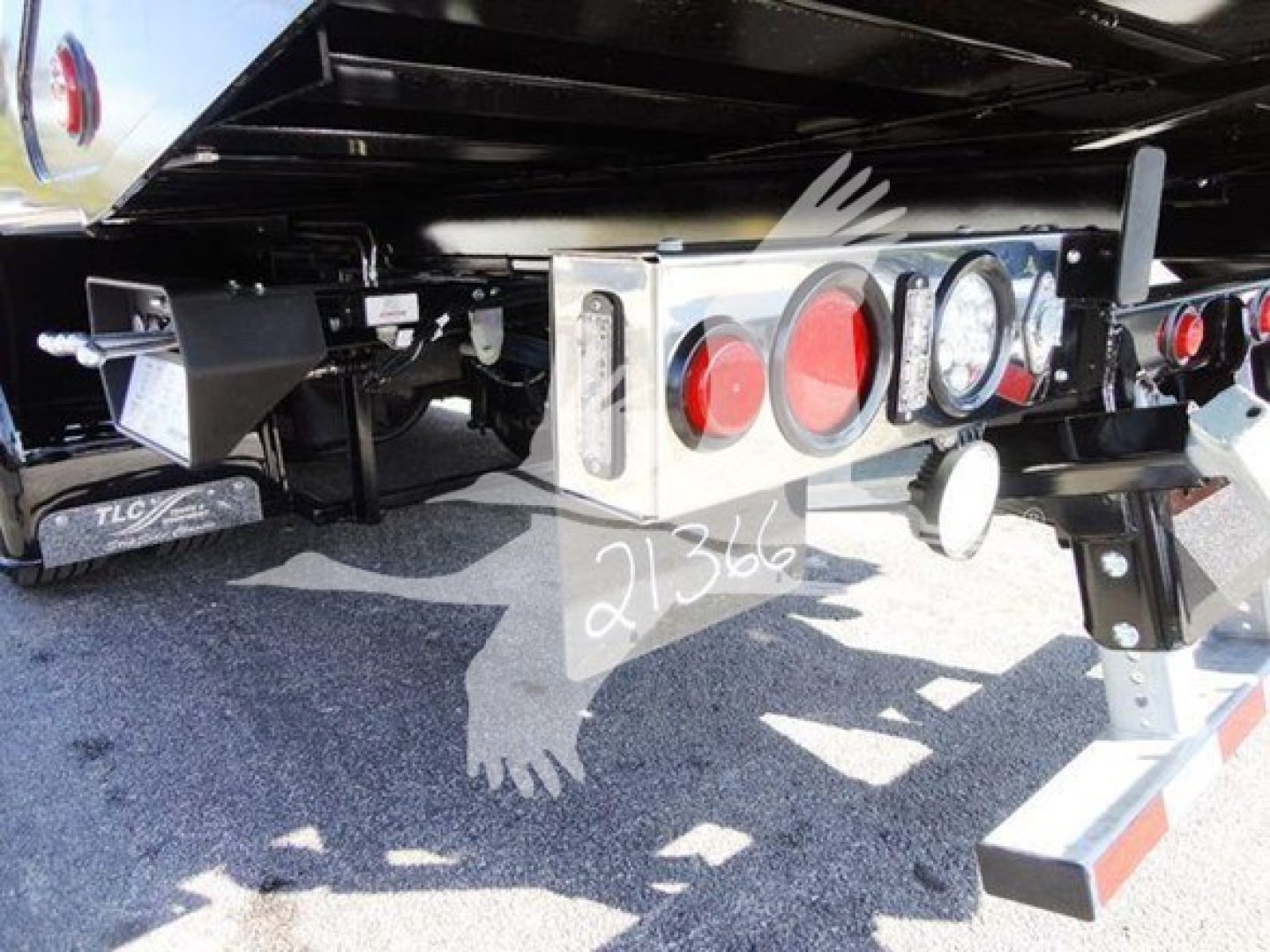 Back of 2022 International MV rollback truck showing rear light cluster, bumper, and hitch with hydraulic lines and chrome components.