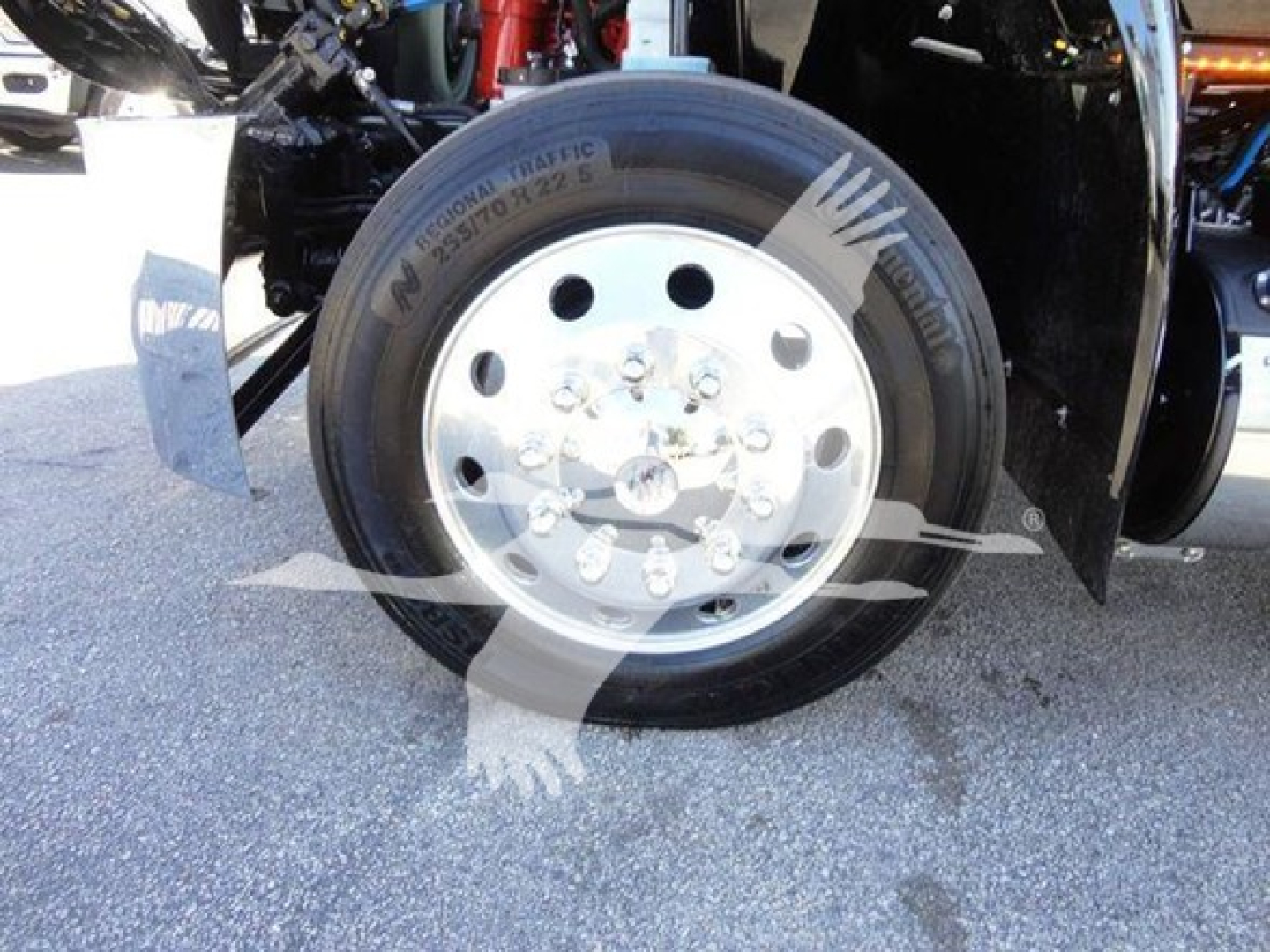Truck wheel and tire close-up showing steel rim and Michelin tire labels visible on the front axle.