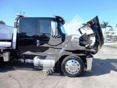 Truck cab with hood open on a rollback truck, black exterior, side view showing fuel tanks and chrome wheels.