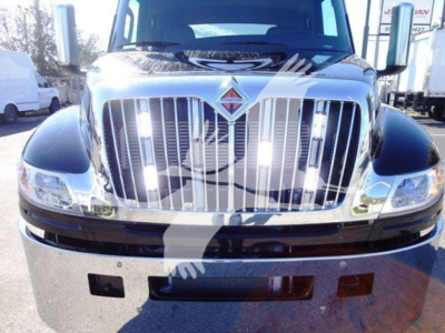Truck front view showing chrome grille and International emblem on hood with headlights and bumper area