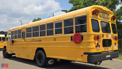 Yellow 2017 Blue Bird Vision school bus rear-side view showing windows, school bus signage, and rear lights.