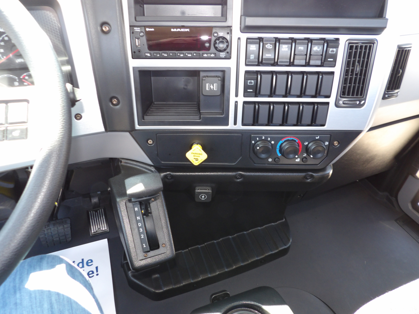 Interior of a 2026 Mack MD7 truck cab showing dashboard controls, radio, climate controls, and steering wheel.