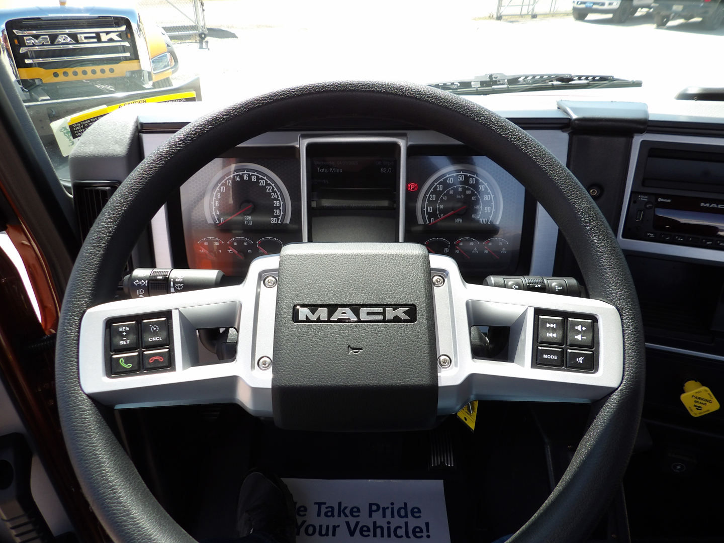 Mack MD7 truck interior showing steering wheel with Mack logo and instrument cluster behind.