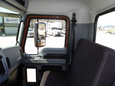 Truck cab interior with door mirror visible through window; side window and dash area; no specific brand labels legible inside the cab.