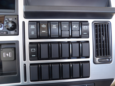 Dashboard area of a 2026 Mack MD7 showing multiple switches labeled diff lock, PTO, mud/snow, ATC off, and other controls.