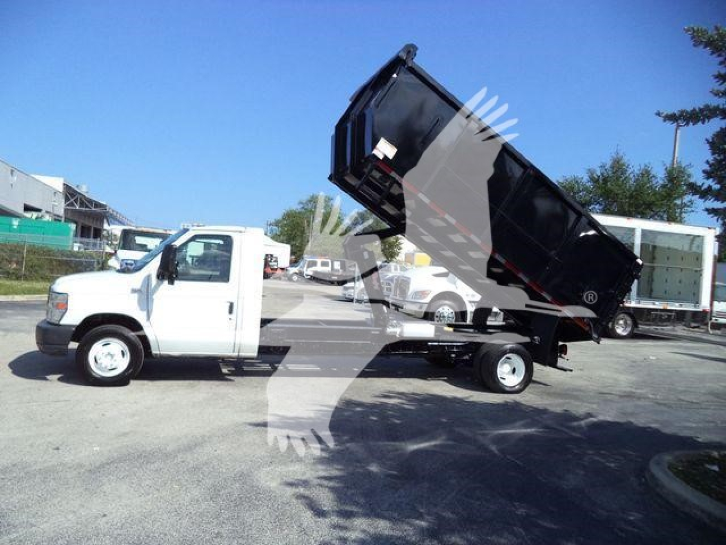 2011 Ford E450 dump truck with bed raised showing side view and front cab; no legible labels or stickers visible on the truck bed.