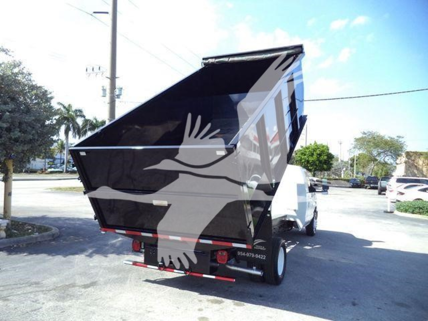 Dump truck bed of a 2011 Ford E450 dump truck in raised position showing rear lights and hydraulic system.