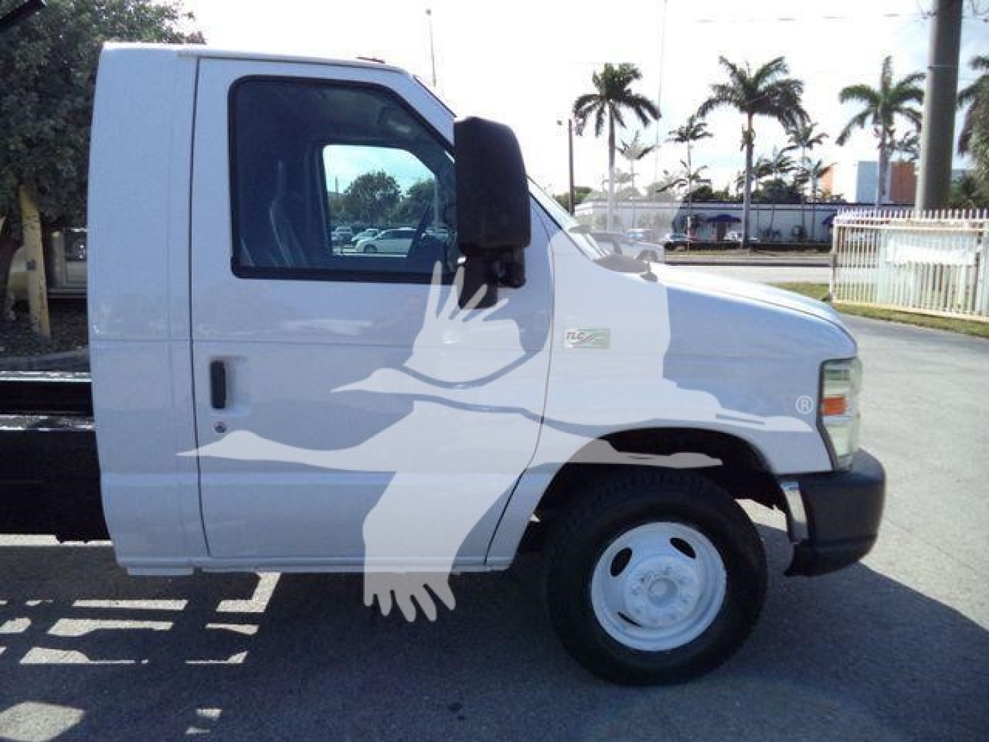 Ford E450 box truck cab in profile view showing front wheel and door, white exterior with black side mirror and bumper.