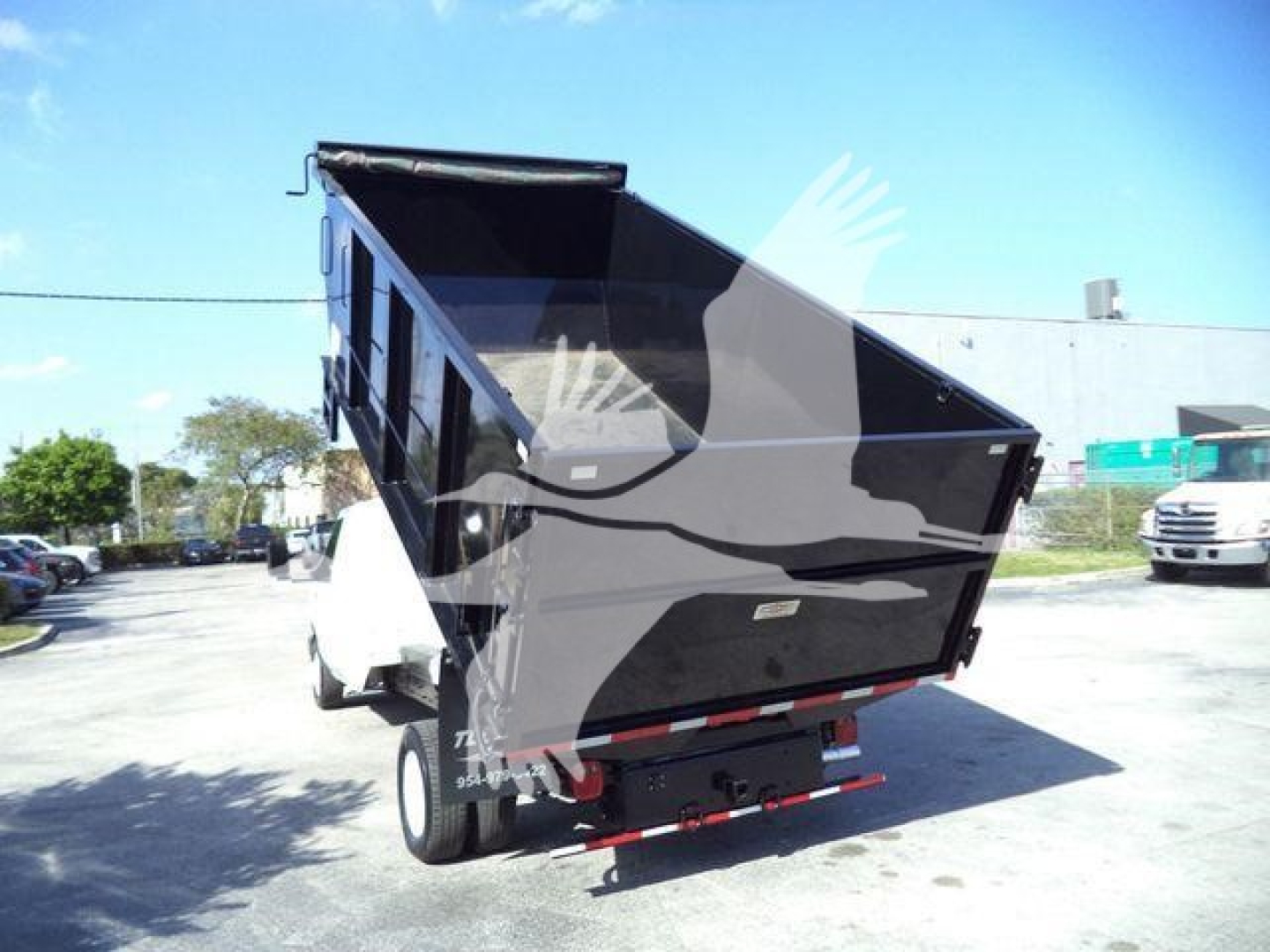 Ford E450 dump truck with rear dump bed raised, view of the bed and rear bumper.