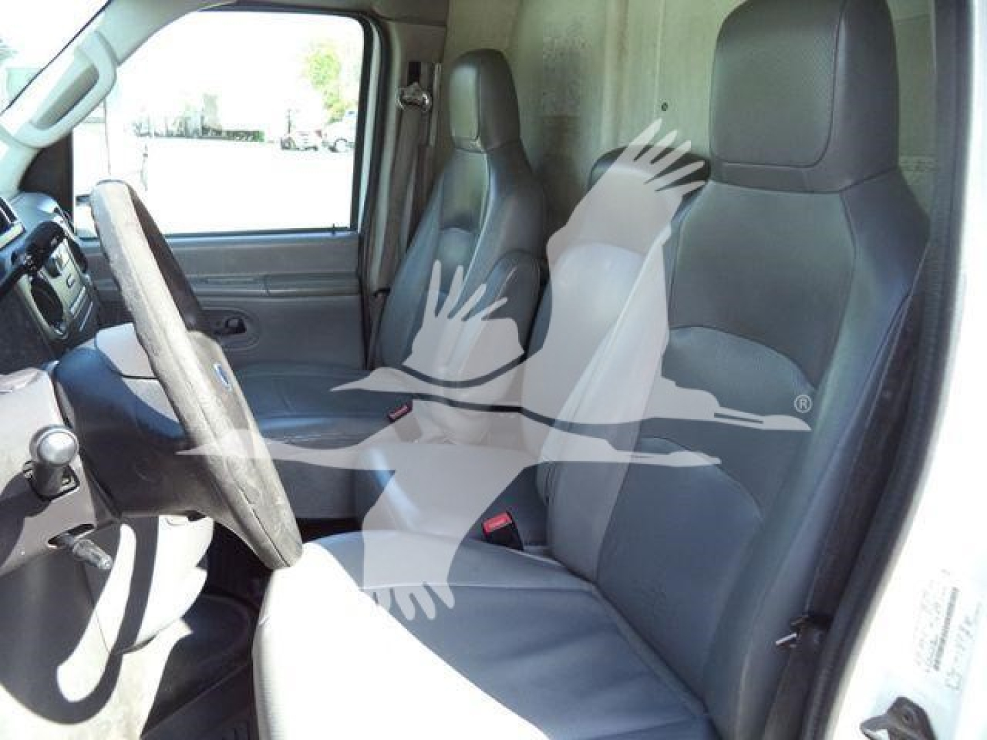 Cab interior of a 2011 Ford E450 dump truck showing driver and passenger seats and steering wheel.