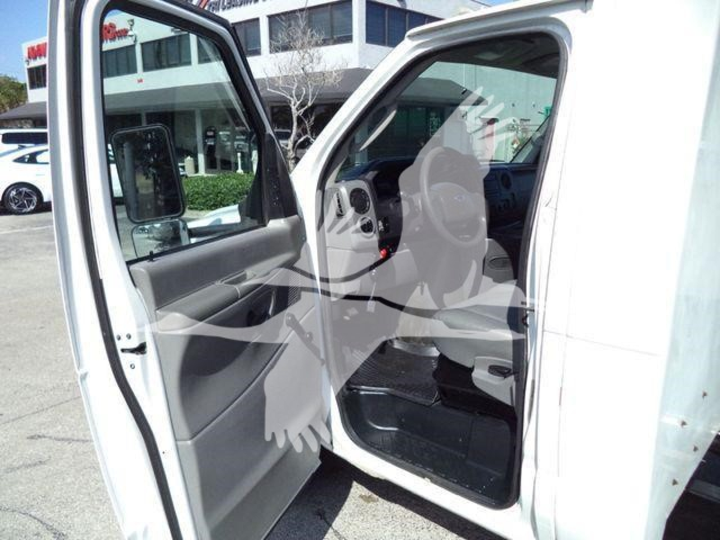 Ford E-450 cargo van interior view with front passenger door open showing dash and seat area.