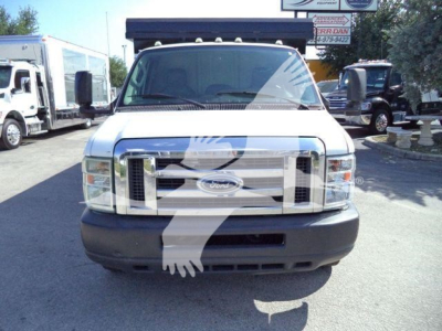 Ford E-450 front view showing large chrome grille, headlights, and black front bumper in a truck lot.