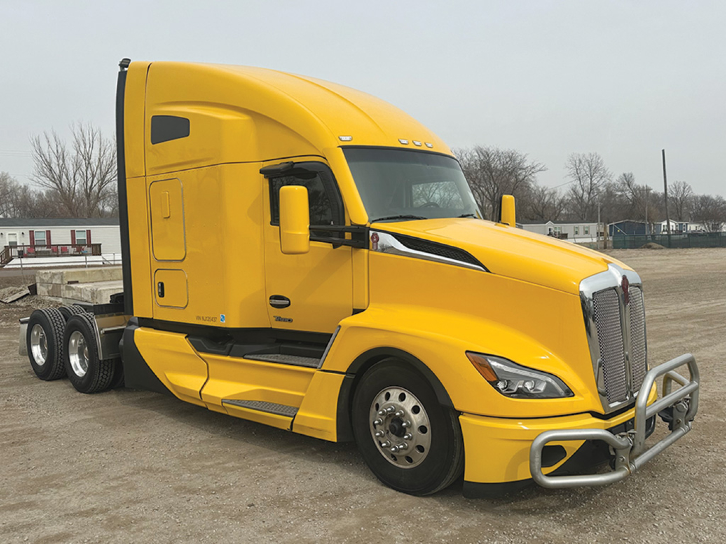 Kenworth T680 Next Gen tractor in yellow, side view showing cab, front grille, and wheel assemblies.