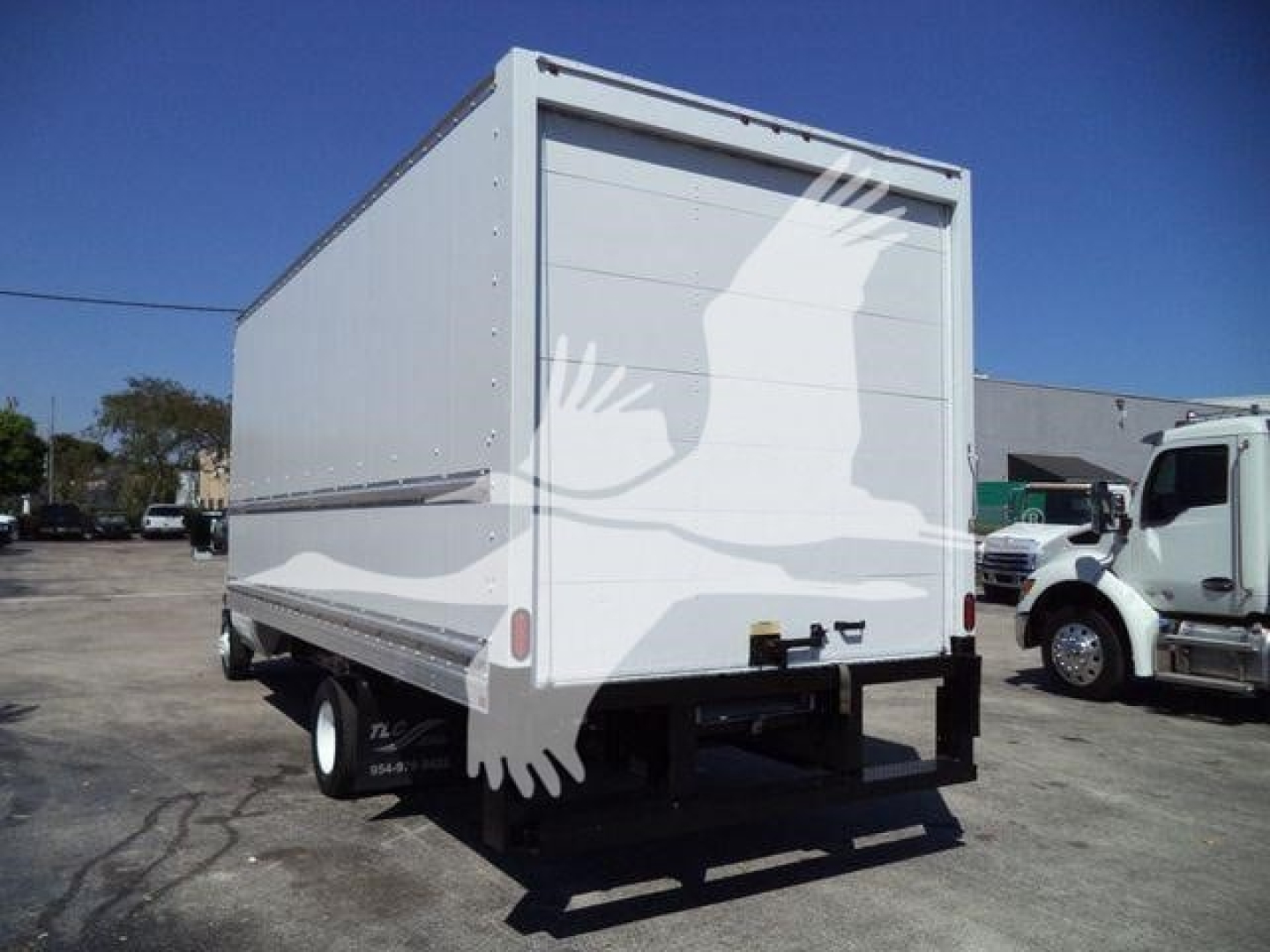 Box truck cargo area of a 2011 Ford E450 with a high cube box, rear view showing closed roll-up door, black bumper, and dual rear wheels.