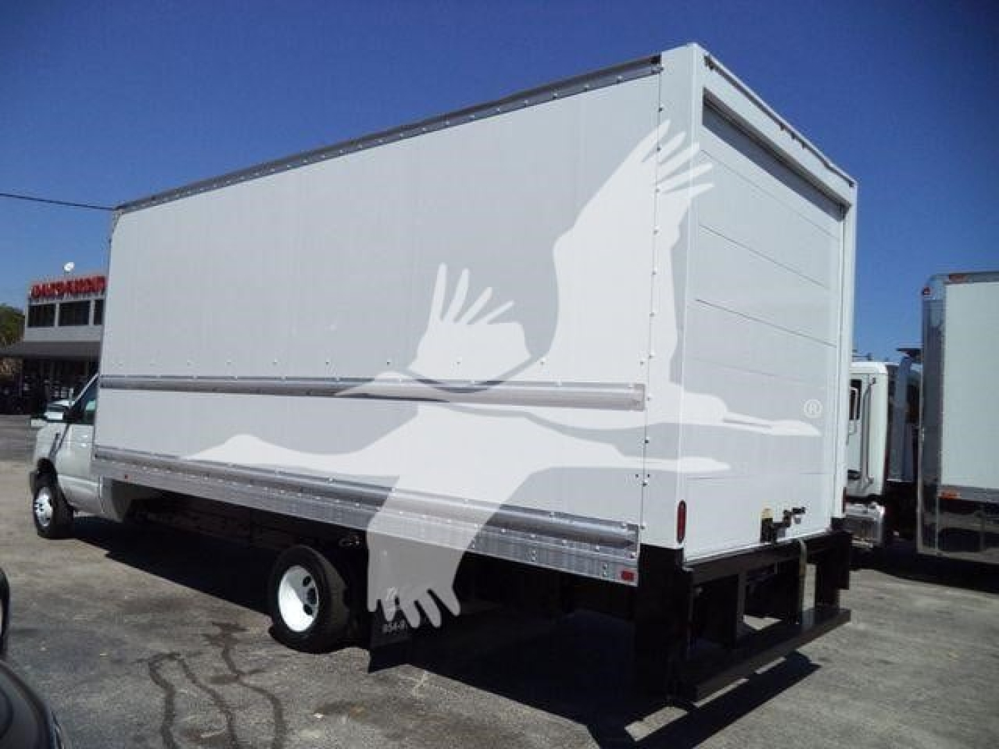 Box truck rear and side view showing cargo box with white bird graphics on white paint.