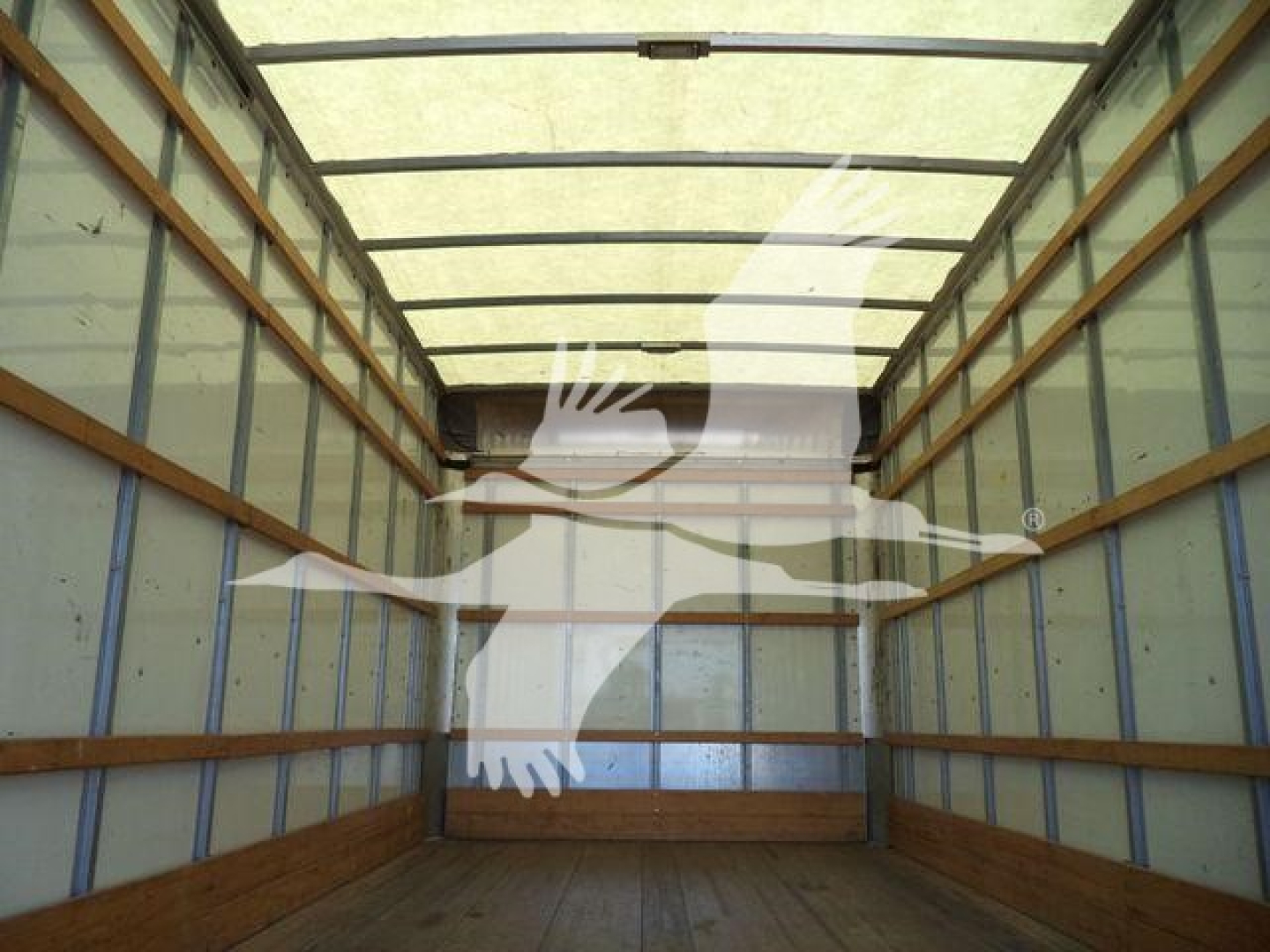 Truck cargo area of a 2011 Ford E450 box truck interior showing empty wood floor and metal side walls