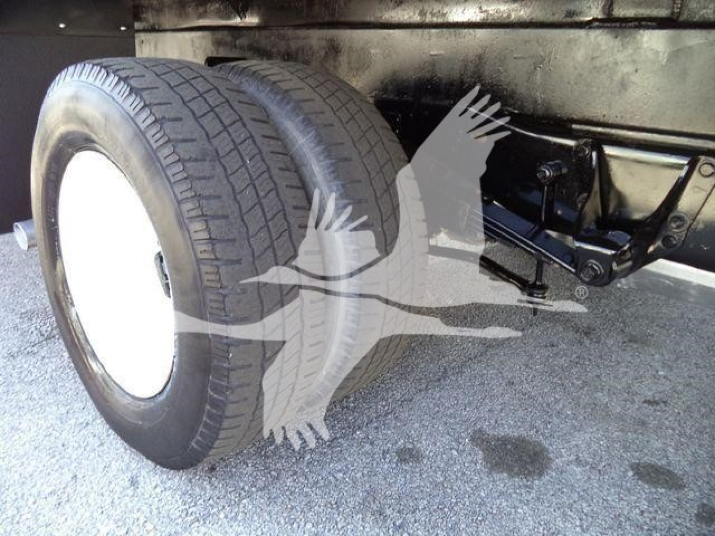 Ford E450 chassis showing dual rear wheels and hitch area underbox; visible tires and suspension components.