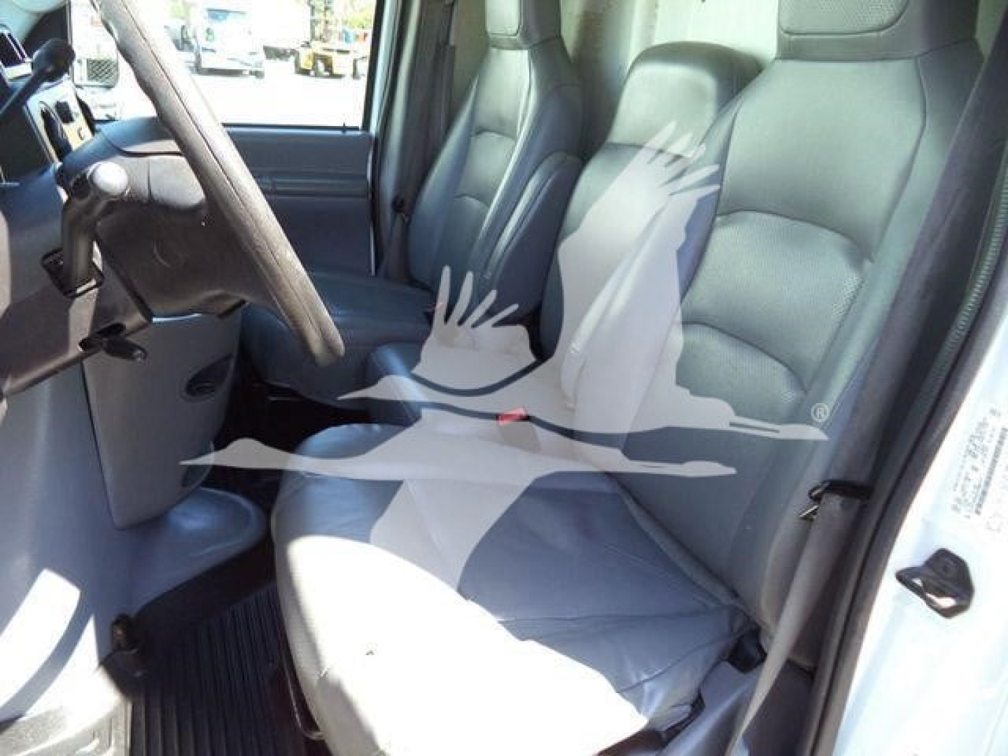 Ford E-450 interior front seats and driver area showing gray cloth seats and steering wheel in right-hand drive perspective.