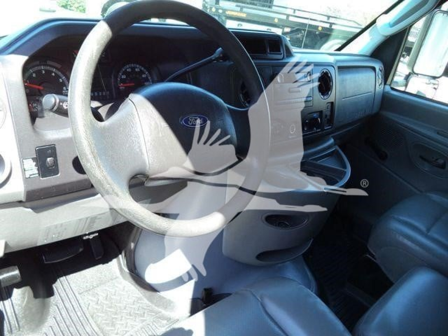 Ford E-450 cargo van interior showing steering wheel and dashboard with Ford emblem, gauge cluster, and center console.