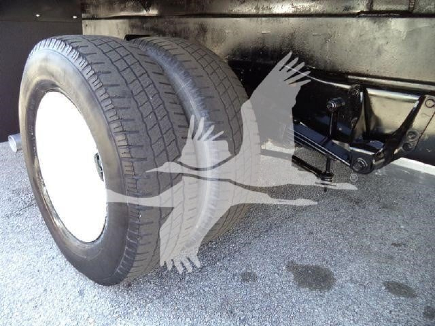 Ford E-450 box truck rear dual wheels and suspension visible undercarriage with tires and chassis components.