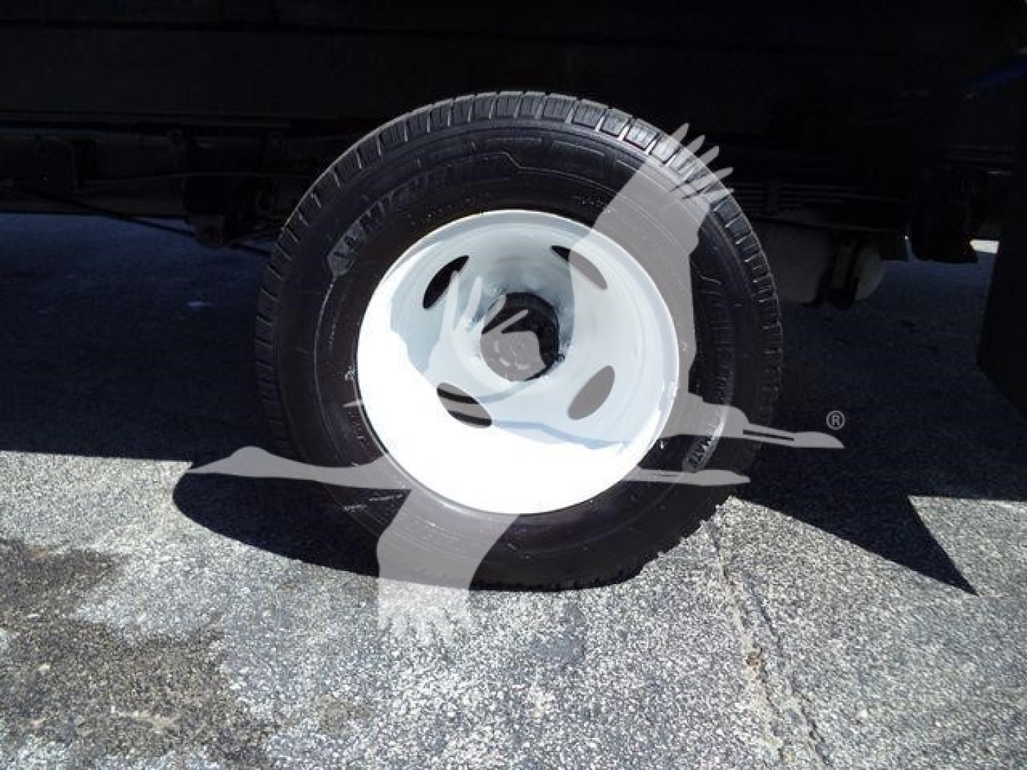 Ford E-450 wheel and tire undercargo area showing white steel rim and tire tread.