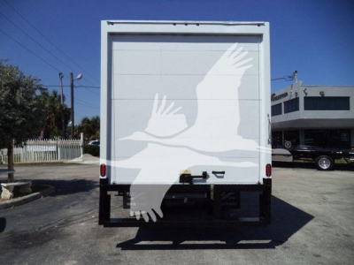 Rear view of a white box truck with a large white bird or eagle graphic on the back doors. No visible text other than the stock and VIN data may be on a separate sign; the image shows a loading deck and taillights.