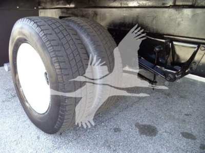 Ford E450 box truck rear axle with dual rear tires and leaf spring suspension visible in wheelwell.