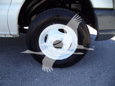 Ford E450 wheel and tire in foreground with partial truck body visible.